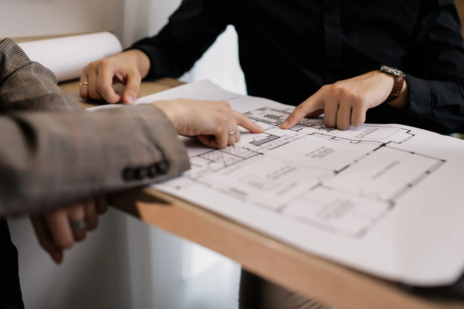 Ręce projektanta nad szkicem i planem nasadzeń skweru na stole, materiały projektowe w tle