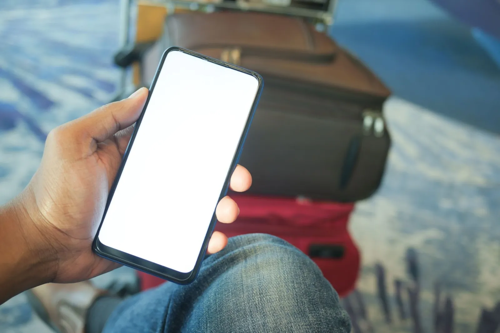 Osoba sprawdzająca rezerwację na telefonie przed wyjściem, rzeczy spakowane gotowe do wyjścia