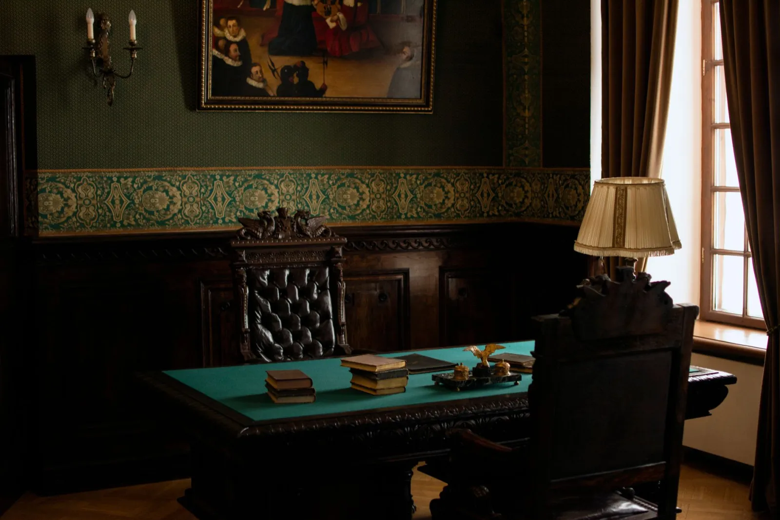 Luxurious antique office interior in a historic palace setting featuring an old-fashioned wooden desk and chair.