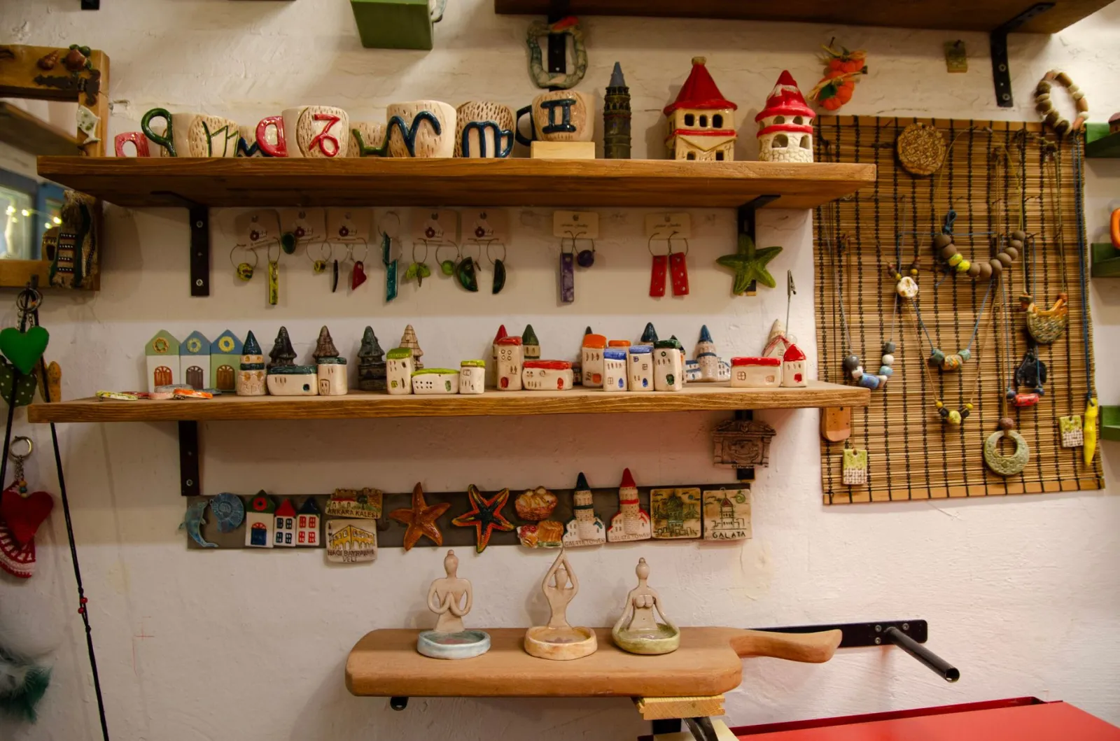 Stół z wyeksponowanymi ręcznie wykonanymi przedmiotami: ceramiką, biżuterią i drewnianymi drobiazgami.