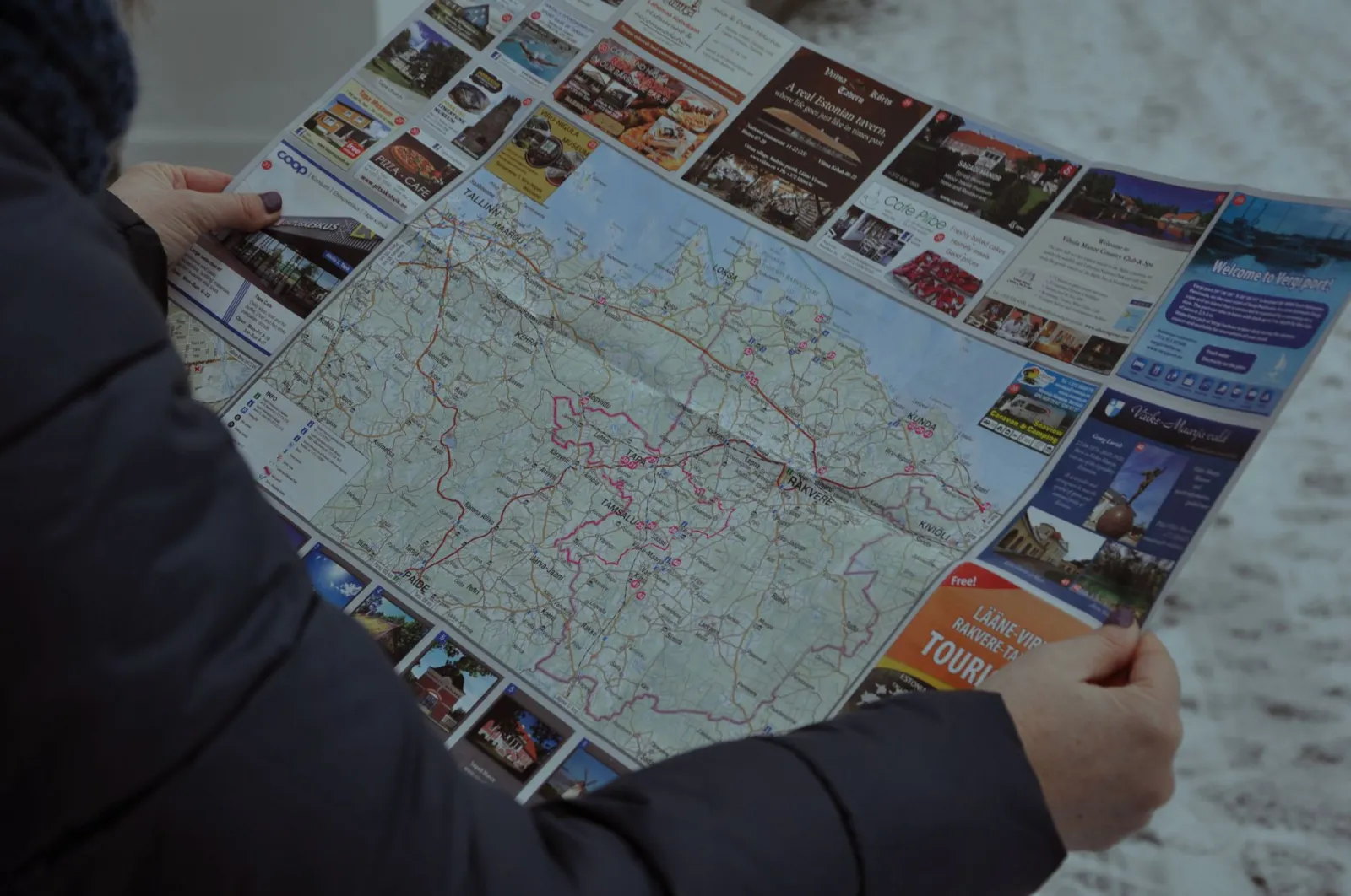 Mapa z zaznaczoną trasą spacerową trzymana w dłoniach podróżnika